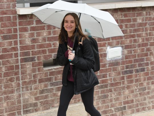 KEEPING DRY: Texas State students try to avoid the rain Tuesday morning