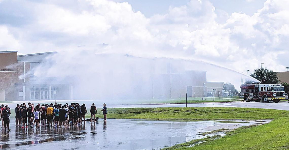 WELCOMED SHOWER: San Marcos Fire Department quenches Rattler band WELCOMED SHOWER