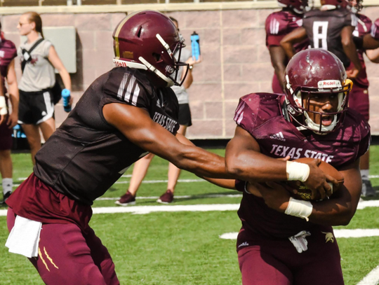 Redshirt freshman quarterback Jaylen Gipson hands off the ball during Texas State's scrimmage on Saturday