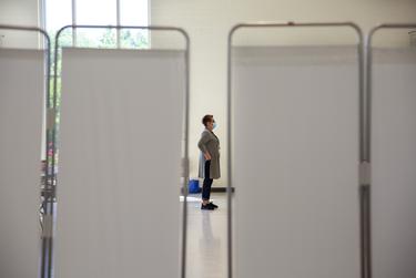 Paola Gonzalez, a contracted workers with Texas Department of State Health Services, waits as people go through the vaccination process at the Tennison Memorial United Methodist Church in Mt. Pleasant on May 7, 2021.