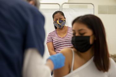 Maria Campos watches her daughter Vicky Martinez receive the COVID-19 vaccine at the Tennison Memorial United Methodist Church in Mt. Pleasant on May 7, 2021.