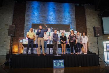 Paul Stell calls people forward before announcing Proposition A passed during a watch party in Trinity Church on Saturday, May 1, 2021, in Lubbock Texas.